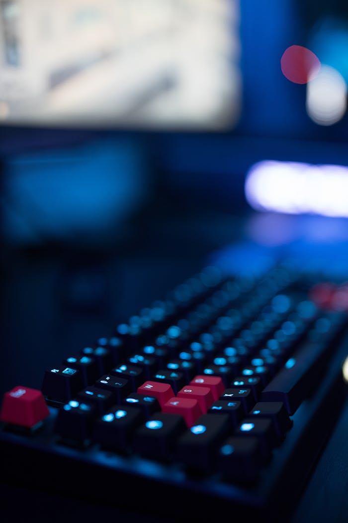 about-us-01 A focused shot of a gaming keyboard with illuminated keys, showcasing modern tech design.